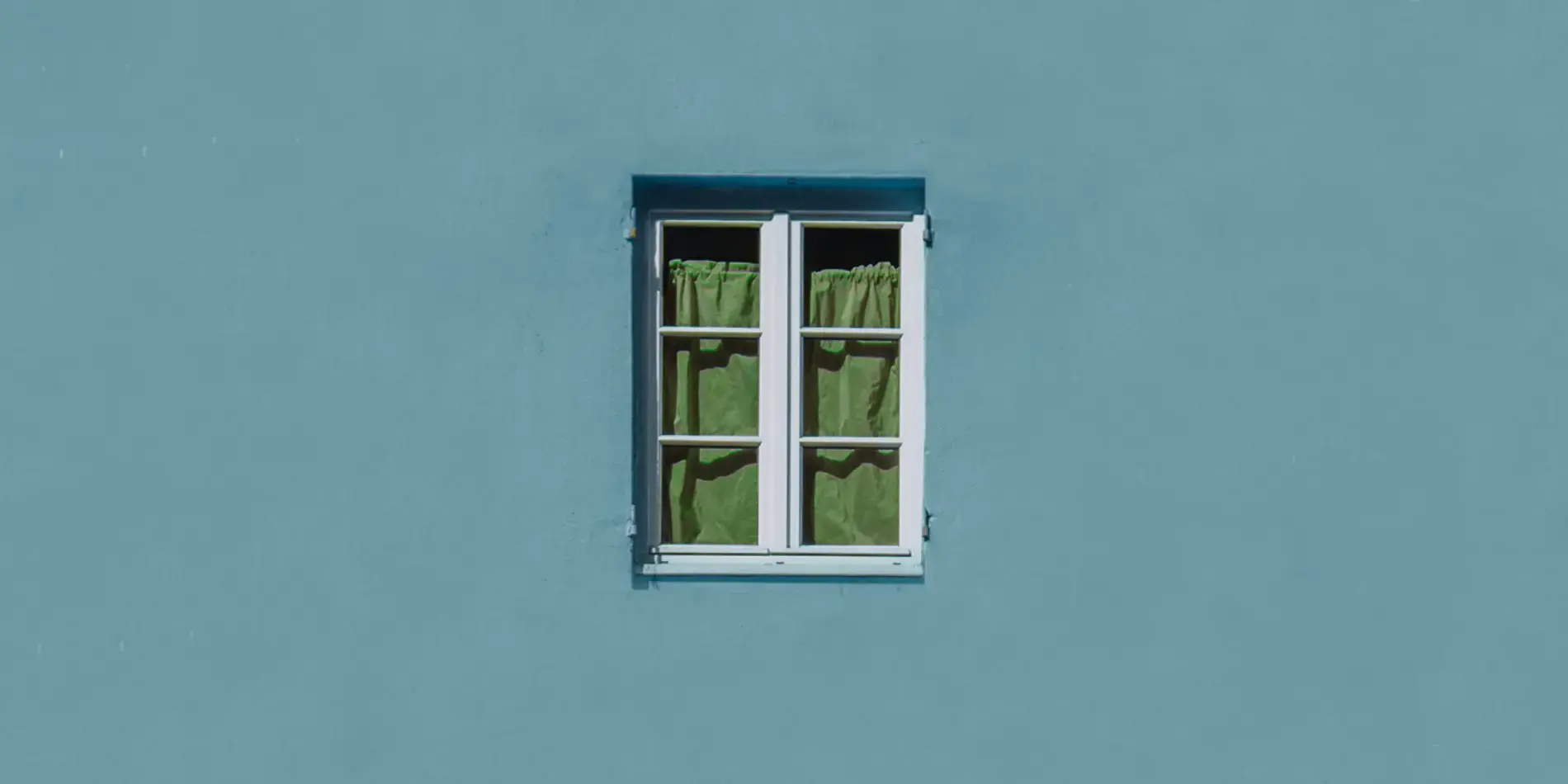 window of house with green curtains